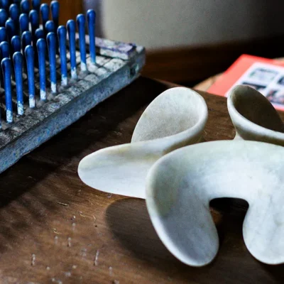 an organic shaped marble object and a vintage latex mould wih many protrusions create an artistic contrast with each other. a link to our unique finds department